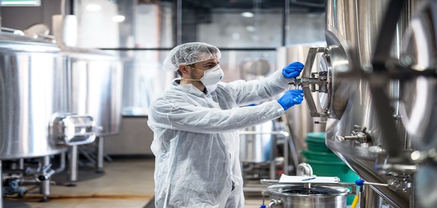 Homem mexendo em válvulas na indústria alimentícia