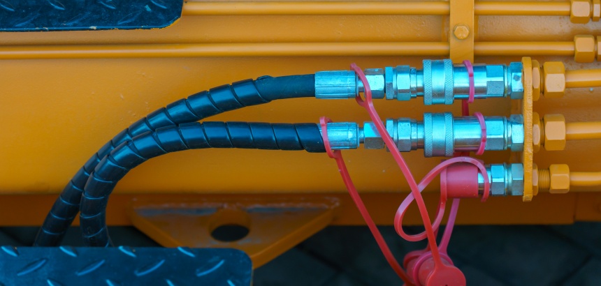 Conexões pneumáticas em sistema industrial com mangueiras e acoplamentos metálicos.